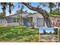 Charming single-story home featuring a stone accent, a manicured lawn, and mature landscaping, great curb appeal at 4535 15Th S Ave, St Petersburg, FL 33711