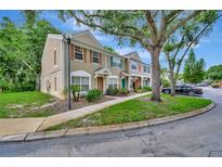 Charming townhome featuring neutral stucco and wood accents, with mature trees surrounding the property at 5502 Carrollwood Key Dr, Tampa, FL 33624