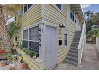 Charming yellow exterior of building with white trim and front door and stairway entrance at 659 26Th S Ave, St Petersburg, FL 33705