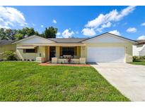 Charming one-story home with a well-maintained lawn and a two-car garage at 8720 Briar Patch Dr, Port Richey, FL 34668
