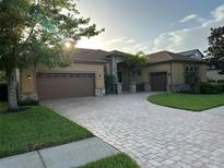 Stunning home with a paver driveway, mature landscaping, and a three-car garage at 1008 Arista Blvd, Valrico, FL 33594