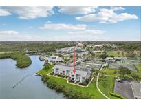 Aerial view of a condo complex with waterfront access, pool, and tennis courts at 14800 Walsingham Rd # 1215, Largo, FL 33774