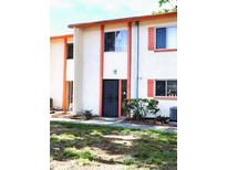 Charming townhouse featuring stucco walls, coral trim, and decorative shutters at 1620 58Th N Ave # 6, St Petersburg, FL 33712