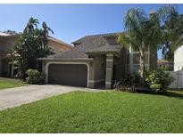 Charming two-story home featuring a well-maintained lawn and mature trees in a serene, suburban setting at 3304 W Harbor View Ave, Tampa, FL 33611