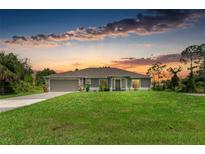 Charming single-story home featuring a well-maintained lawn, neutral tones, and an attached two-car garage at 3682 Johnstown St, North Port, FL 34288