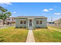 Charming single-story home featuring a well-manicured lawn, white picket fence, and light-blue exterior at 3940 Miramar S Way, St Petersburg, FL 33705
