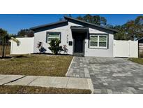 Charming single-story home featuring gray stucco, a brick driveway, and tasteful landscaping at 4029 9Th S Ave, St Petersburg, FL 33711