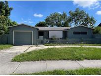 Charming single-story home with a fenced front yard, driveway, and attached garage at 4591 54Th N Ave, St Petersburg, FL 33714
