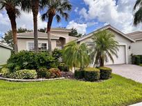 Well-maintained home with mature landscaping, beautiful lawn, and brick paver driveway at 4950 Sandy Brook Cir, Wimauma, FL 33598
