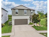 Charming two-story home featuring a two-car garage and a well-manicured lawn, creating a welcoming curb appeal at 5522 Appleton Shore Dr, Apollo Beach, FL 33572