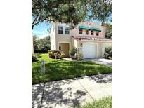 Charming two-story home features a terracotta roof, green awnings, and a well-maintained lawn at 5644 Samter Ct, Tampa, FL 33611