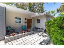 Charming home entrance featuring a cozy seating area and lush landscaping leading to the front door at 6334 22Nd N Ave, St Petersburg, FL 33710