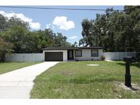 Charming single-story home featuring a well-manicured front yard, private drive, and a neutral exterior at 814 W 131St Ave, Tampa, FL 33612