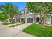 Charming townhouse featuring a well-maintained lawn and gray exterior at 10208 Westpark Preserve Blvd, Tampa, FL 33625