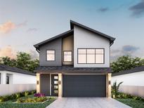 Modern two-story home with gray and white accents, large windows, and a two-car garage at 12236 Land St, Largo, FL 33773