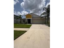 Charming single-story home featuring a two-car garage, well-maintained lawn, and inviting entrance at 12931 Twin Bridges Dr, Riverview, FL 33579