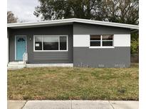 Charming single-story home featuring a blue door and well-maintained front lawn at 1317 Tyrone N Blvd, St Petersburg, FL 33710