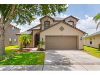 Charming two-story home featuring a two-car garage, beautiful landscaping, and a welcoming front yard at 18508 Merseyside Loop, Land O Lakes, FL 34638