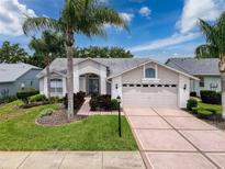 Charming single-story home with well-manicured lawn, mature landscaping, and a welcoming front entrance at 18549 Grand Club Dr, Hudson, FL 34667