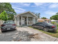 Charming single-story home with a welcoming front porch and well-maintained front yard with driveway and multiple cars at 2108 E Linebaugh Ave, Tampa, FL 33612