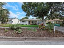 Charming one-story home featuring lush landscaping and a well-maintained front yard, enhancing its curb appeal at 245 Grove Cir N, Dunedin, FL 34698