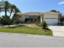 Charming single-Gathering home with stone accents, a well-manicured lawn, and lush tropical landscaping at 4434 Dewey Dr, New Port Richey, FL 34652