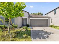 Charming single-Gathering home featuring a 2-car garage, well-maintained lawn, and appealing curb appeal at 4726 Wild Senna Blvd, Tampa, FL 33619