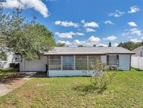 Charming single-story home featuring a screened-in porch, attached garage, and well-maintained front yard at 4911 Bartelt Rd, Holiday, FL 34690
