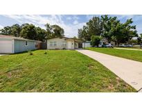Charming single-story home with a well-maintained lawn and covered parking at 5519 Kelly N Dr, St Petersburg, FL 33703