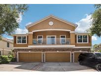 Two-story home featuring a balcony, a three-car garage, and a stone-accented facade at 7001 Interbay Blvd # 203, Tampa, FL 33616