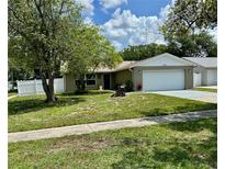 Charming single-story home features a well-manicured lawn and attached two-car garage at 7301 Mitchell Ranch Rd, New Port Richey, FL 34655