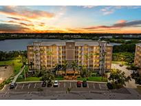 Exterior view of the residence complex with parking, palm trees, and a beautiful sunset backdrop at 10002 Key Haven Rd # 503, Seminole, FL 33777