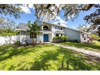 Charming two-story home with blue double-door entrance, mature landscaping and healthy green grass at 11203 Egret Nest Ct, Riverview, FL 33569