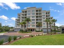 Luxury waterfront condo building featuring multiple balconies, lush landscaping and porte-cochere entrance at 125 Belleview Blvd # 503, Belleair, FL 33756