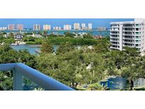 Scenic waterfront view with lush greenery, a glimpse of the cityscape, and a modern high-rise building at 125 Belleview Blvd # 503, Belleair, FL 33756
