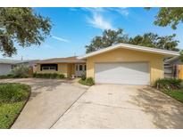 Charming single-story home with a well-maintained lawn and a spacious two-car garage with a long driveway at 1370 Hill Dr, Largo, FL 33770