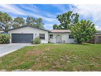 Charming single-story home with a well-maintained lawn and a gray two-car garage at 1586 Linwood Dr, Clearwater, FL 33755