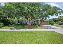 Charming single-story home with blue exterior paint, a well-manicured lawn, mature shade trees, and a two-car garage at 1711 N Highland Ave, Clearwater, FL 33755