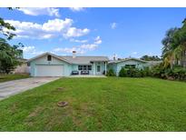 Charming light blue single story home with a well-manicured lawn and a spacious driveway at 1825 Welland Dr, Clearwater, FL 33756