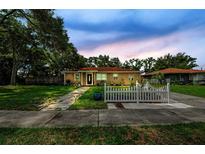 Charming single-story home with a well-manicured lawn and a cute white picket fence, enhancing its curb appeal at 1893 Harding St, Clearwater, FL 33765