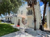 Charming two-story house with a wrought-iron balcony, arched entry, and lush palm trees in a desirable neighborhood at 2222 E 10Th Ave, Tampa, FL 33605