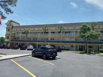 Condo building exterior with parking lot, palm trees and well maintained landscaping on a sunny day at 2459 Franciscan Dr # 29, Clearwater, FL 33763