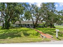Charming single story home with a well manicured lawn and mature trees covered in spanish moss at 358 Highland Shores Dr, Ellenton, FL 34222