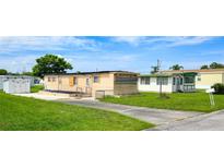 Residential homes feature a mix of siding, including beige, with mature trees accenting the landscape at 37302 Carol Ave, Zephyrhills, FL 33542