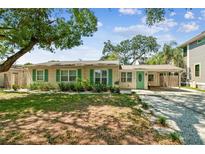 Charming single-story home featuring a light yellow exterior, green shutters, and a welcoming front yard at 4417 W El Prado Blvd, Tampa, FL 33629