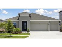 Charming single-story home with a manicured lawn, inviting entrance, and a spacious three-car garage at 5178 Everlong Dr, Apollo Beach, FL 33572