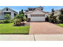 Inviting home with a brick paver driveway and lush landscaping, perfect for curb appeal at 5611 Del Coronado Dr, Apollo Beach, FL 33572