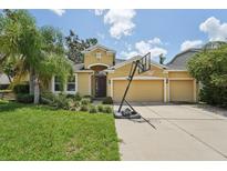 Charming single-Gathering home boasts a three-car garage, well-maintained lawn, and a basketball hoop on the driveway at 6706 Riverside Bluffs Dr, Riverview, FL 33578
