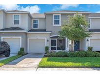 Charming townhome with a well-manicured lawn, blue front door and a one car garage at 7124 Summer Holly Pl, Riverview, FL 33578