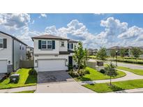 Charming two-story home with brick driveway and manicured lawn at 7517 Notched Pine Bnd, Wesley Chapel, FL 33545